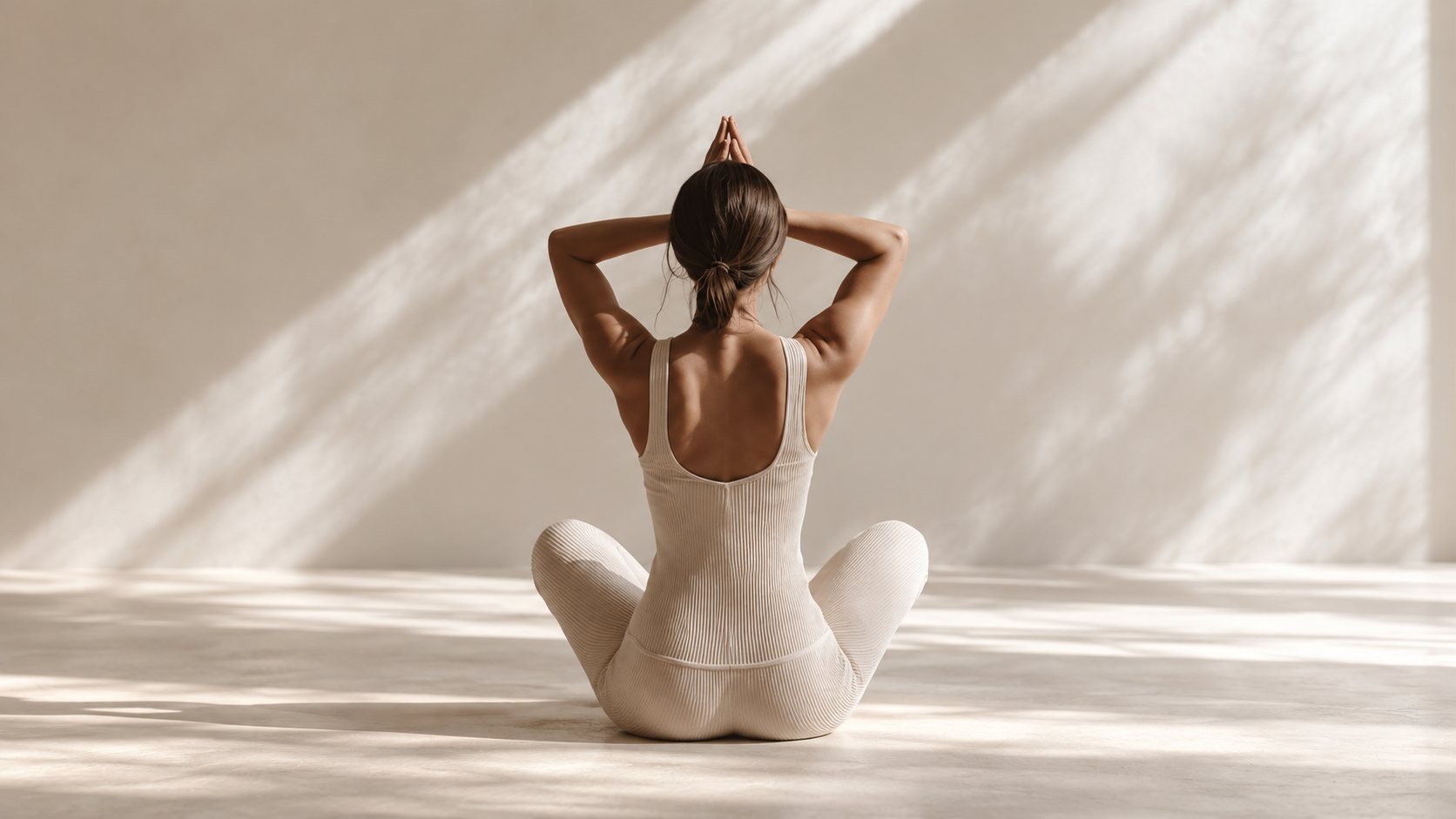 Seated yoga movement in a warm, light-filled studio